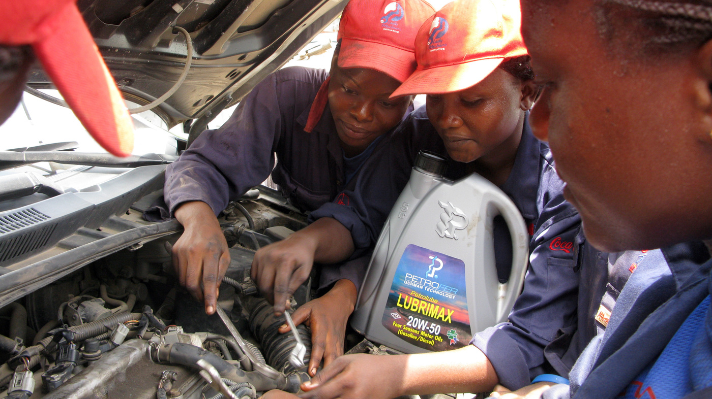 Students at the Lady Mechanic Initiative in Lagos, Nigeria, work on cars in their open air workshop.